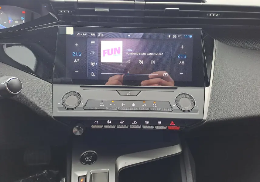 Vue rapprochée de la console centrale noire du Peugeot 308 2025 avec écran tactile et commandes climatisation.