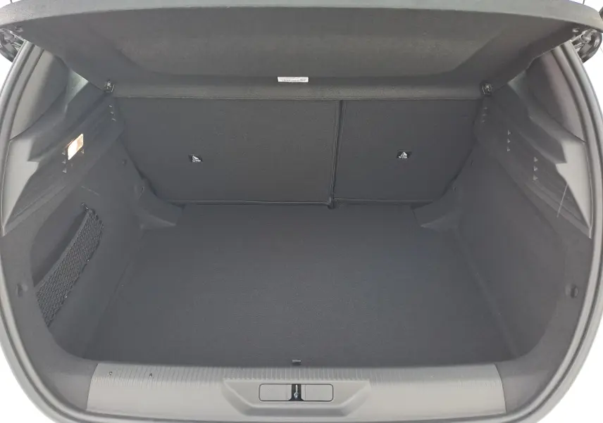 Coffre ouvert vu de l'arrière d'une Peugeot 308 blanche, montrant un espace de chargement propre et spacieux.