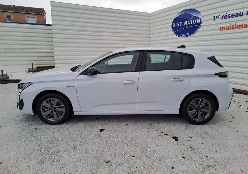 Profil latéral droit d'une Peugeot 308 blanche Okenite, version BlueHDi 130ch Style avec jantes alliage et feux arrière noirs.