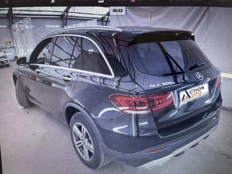 Vue 3/4 arrière droite d’un Mercedes GLC 300e noir avec vitres surteintées et feux arrière LED en intérieur.