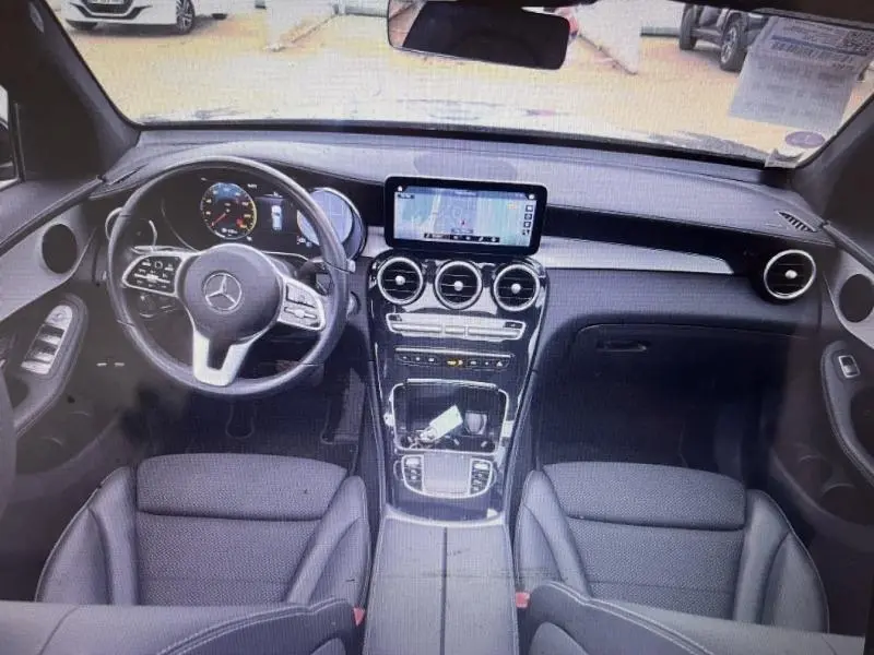Vue intérieure avant du Mercedes GLC 300 e noir, avec tableau de bord moderne et écran central tactile.
