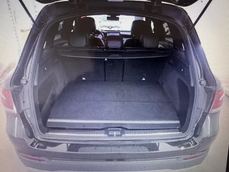 Coffre ouvert vu de l'arrière d'un Mercedes GLC noir, montrant un espace de chargement spacieux et banquette arrière.