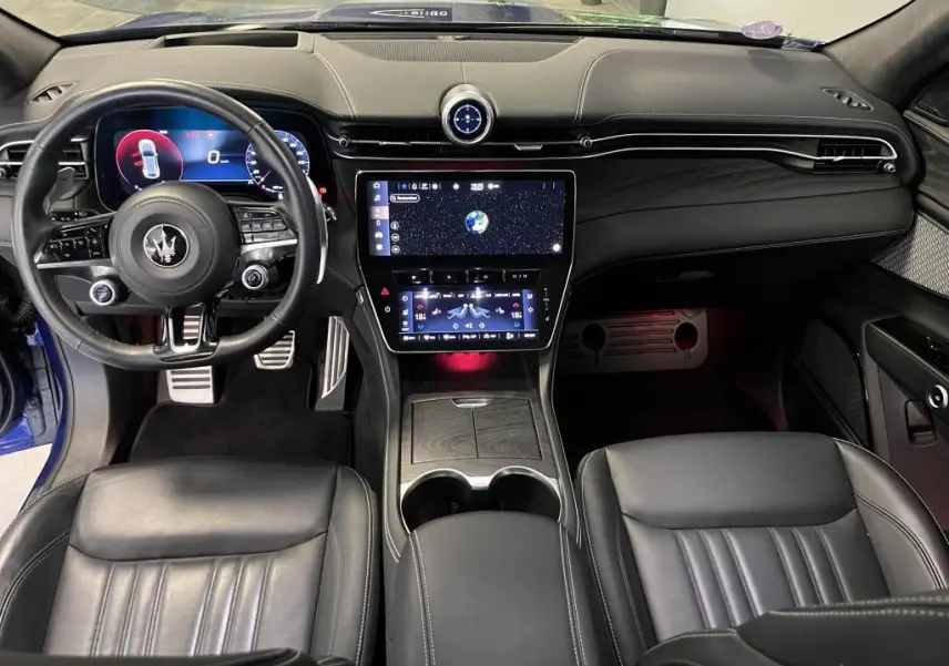 Intérieur noir du Maserati Grecale 2022 vu de face, avec tableau de bord digital et double écran tactile central.