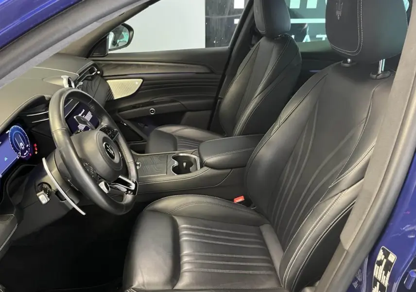 Intérieur avant droit du Maserati Grecale bleu 2022, sièges cuir noirs avec logo Trident brodé sur appuie-tête.