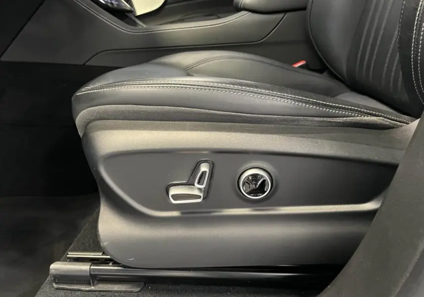 Détail des commandes de réglage électrique du siège conducteur en cuir noir du Maserati Grecale bleu.