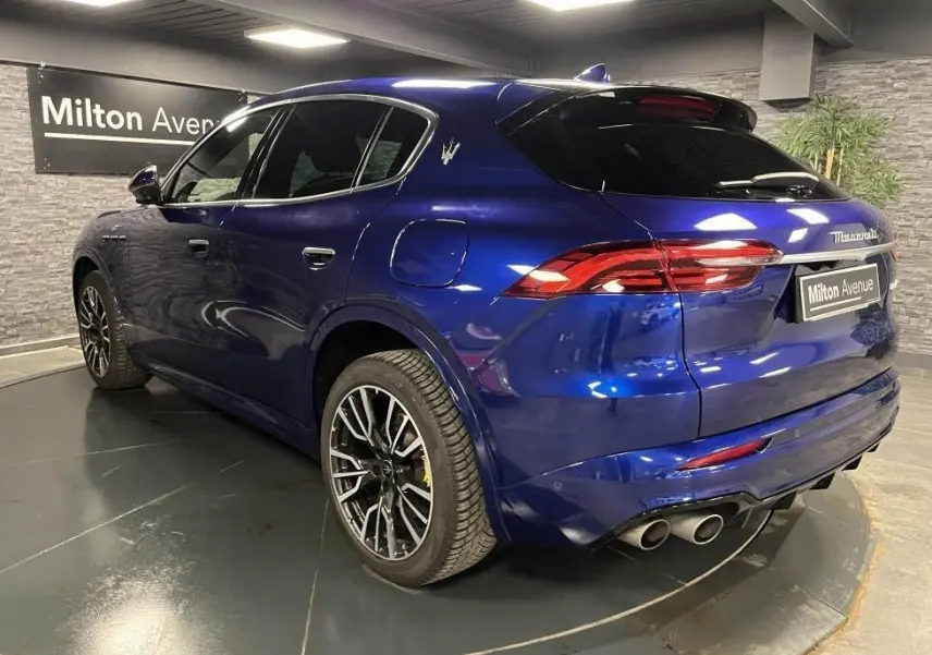 Vue 3/4 arrière droite d'une Maserati Grecale bleu avec étriers de freins jaunes et jantes noires brillantes.