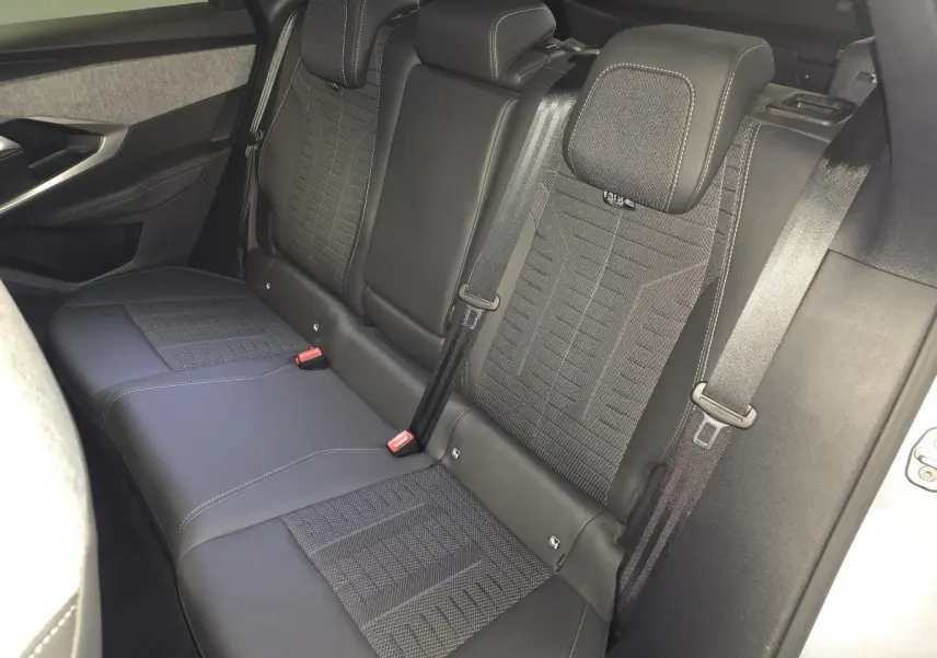 Vue intérieure côté droit des sièges arrière noirs en tissu et cuir du Peugeot 3008 2025 hybride.