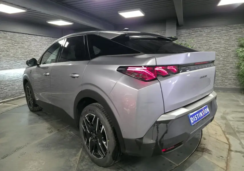 Vue 3/4 arrière droite du Peugeot 3008 gris métallisé avec feux arrière à griffes LED et jantes alliage noires.
