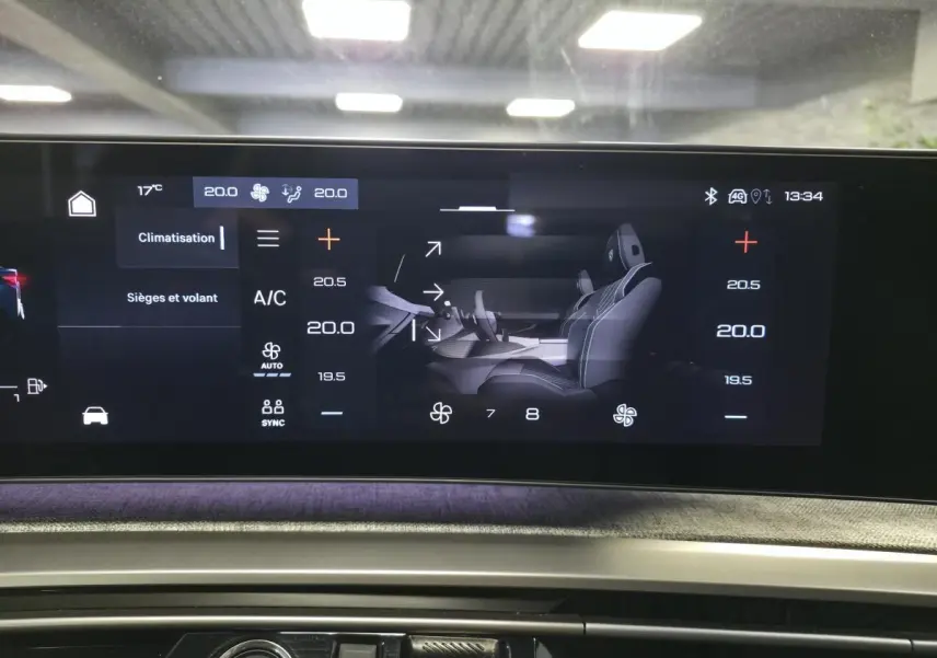 Écran tactile central affichant les réglages de climatisation et sièges du Peugeot 3008 gris, vue intérieure frontale.