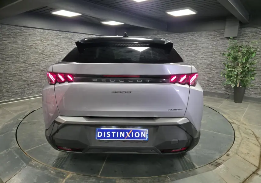 Vue arrière d’un Peugeot 3008 gris hybride 2025 avec feux arrière à griffes LED et bandeau noir laqué.