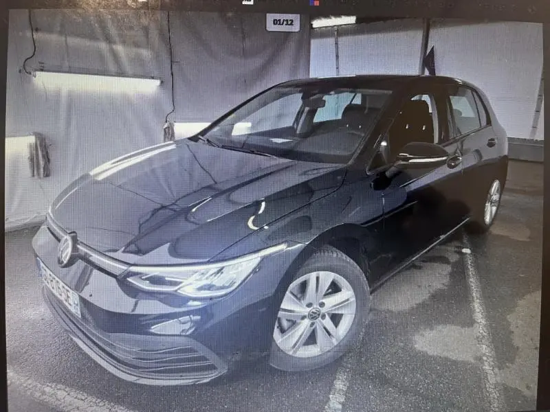 Volkswagen Golf noir intense nacrée vue 3/4 avant droit dans un garage avec jantes alu simples.