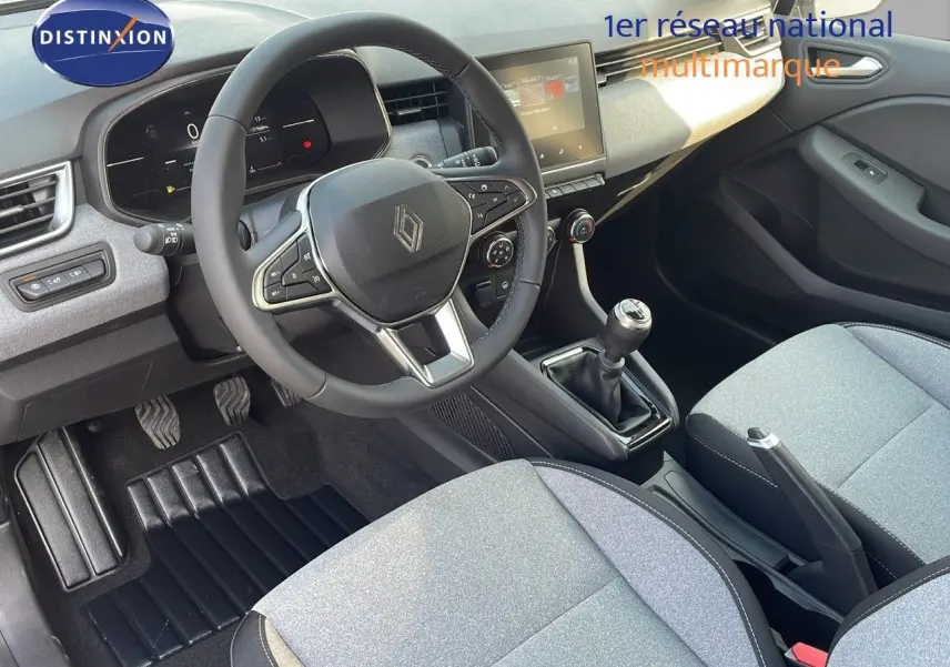 Vue intérieure de la Renault Clio V BluedCi 100ch Evolution 2025, montrant le volant, la boîte manuelle et les sièges gris clair.