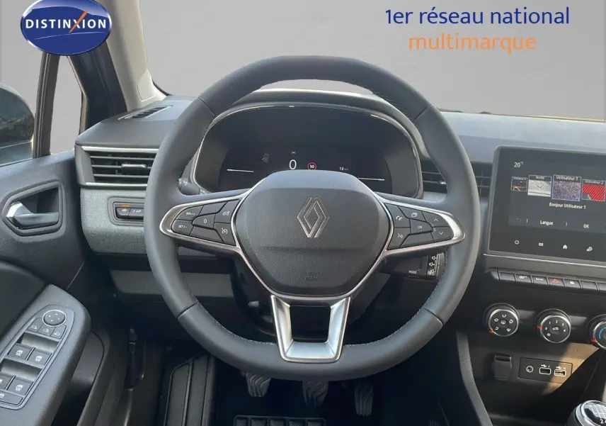 Vue centrée du volant cuir et du tableau de bord numérique d'une Renault Clio gris schiste 2025, avec écran tactile.