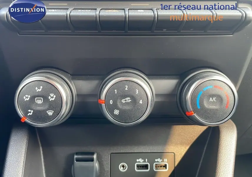 Gros plan sur les commandes de climatisation manuelle avec trois boutons rotatifs dans une Renault Clio gris schiste.