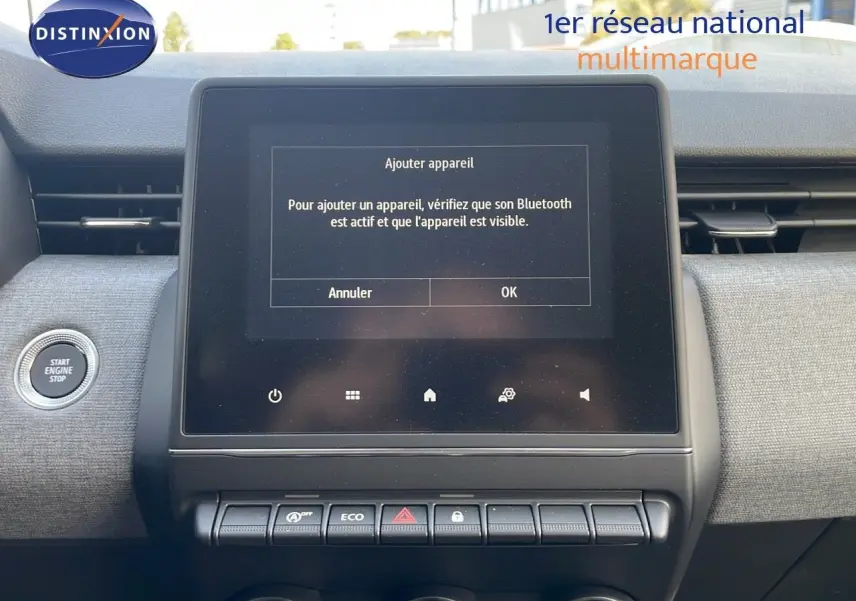 Vue rapprochée de l’écran tactile central et des commandes sur tableau de bord gris clair d’une Renault Clio gris schiste 2025.