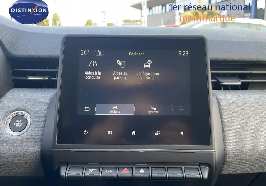 Vue intérieure centrée sur l’écran tactile du tableau de bord de la Renault Clio gris schiste, avec bouton start visible à gauche.