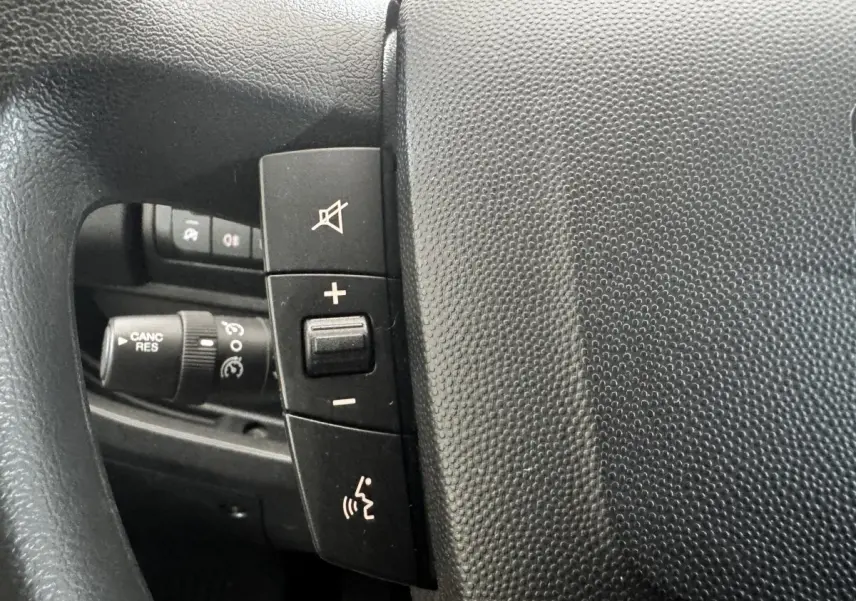 Gros plan sur le volant multifonctions noir du Citroën Jumper 2023, avec commandes de volume et de son.