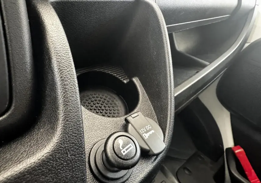 Gros plan intérieur sur la prise 12V et allume-cigare du Citroën Jumper blanc, côté passager avant.