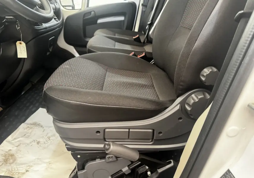 Vue intérieure côté conducteur du siège avant noir avec réglages manuels du Citroën Jumper blanc 2023.
