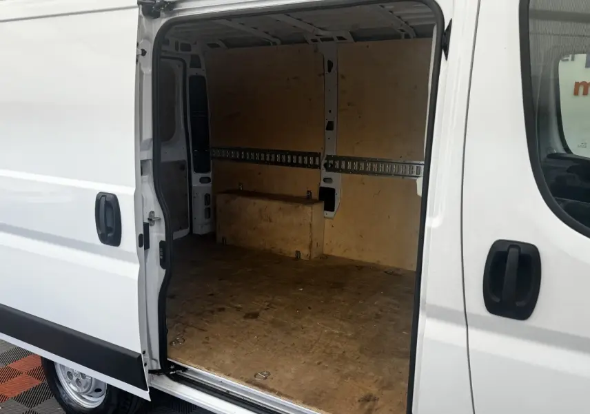 Vue latérale gauche d’un Citroën Jumper blanc 2023 avec porte coulissante ouverte montrant l’espace de chargement vide.