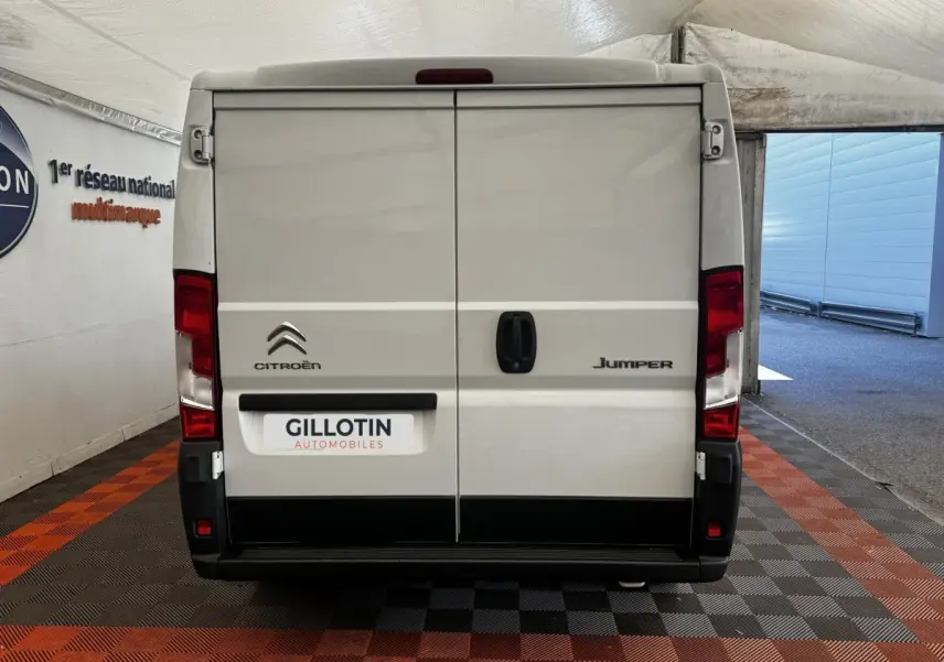 Vue arrière d’un utilitaire blanc Citroën Jumper 33 L1H1, portes fermées avec logo et plaque GILLOTIN.