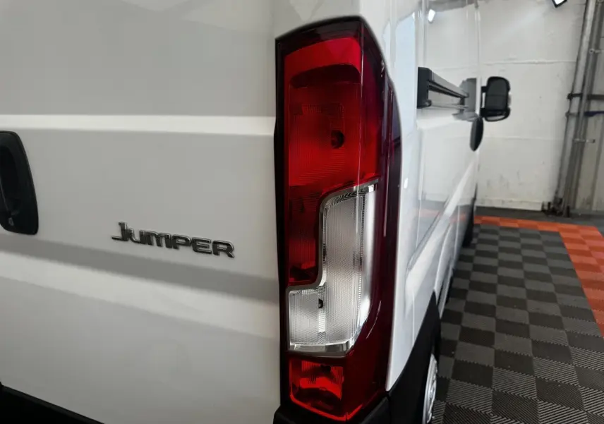 Vue arrière droite du Citroën Jumper blanc 2023, mettant en valeur le feu arrière et le logo Jumper sur la porte.