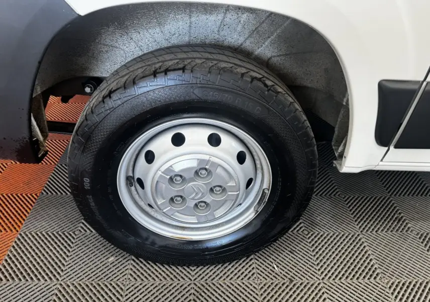 Gros plan sur la roue arrière droite en jante acier argentée du Citroën Jumper blanc, avec partie basse de la carrosserie visible.