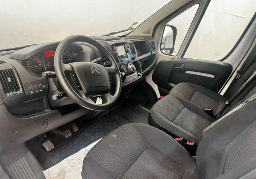 Vue intérieure côté conducteur du Citroën Jumper 2023, volant multifonctions et tableau de bord avec écran tactile.