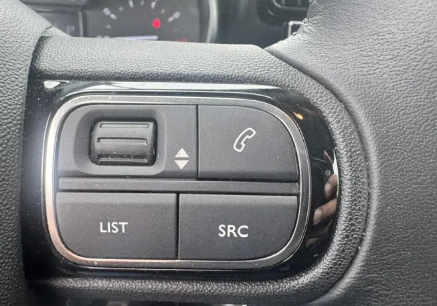 Gros plan sur les commandes audio au volant cuir du Citroën C3 Aircross 2024, côté gauche.
