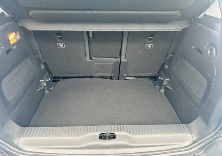Coffre ouvert de Citroën C3 Aircross gris acier, vue intérieure montrant plancher plat et banquette arrière rabattable.