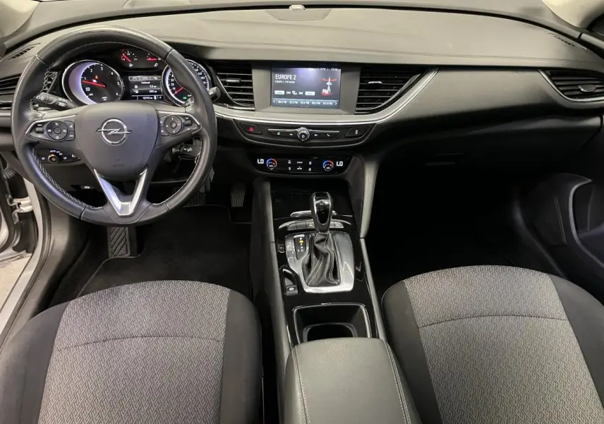 Intérieur Opel Insignia Sports Tourer 2020 vu de face, tableau de bord noir avec écran tactile et sièges tissu gris anthracite.