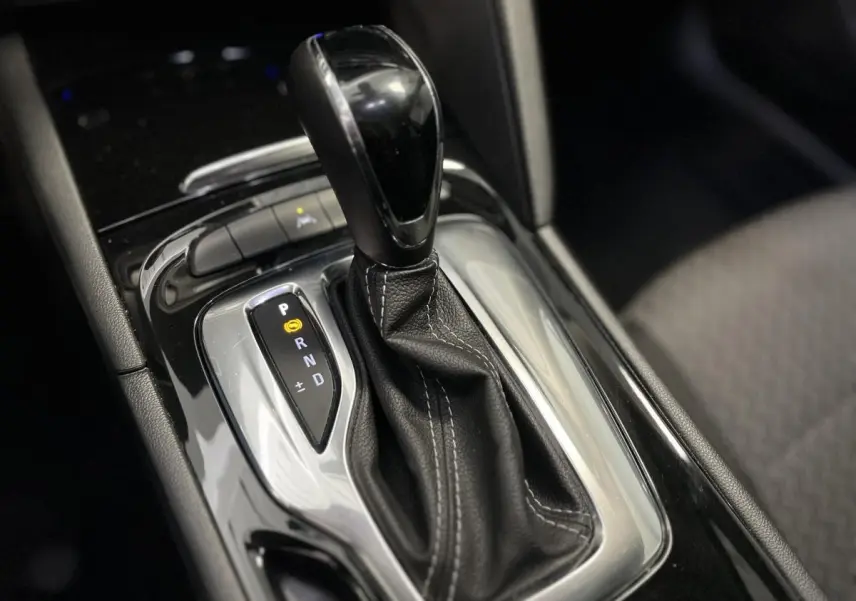 Le levier de vitesses automatique noir avec surpiqûres blanches dans l'habitacle de l'Opel Insignia gris.