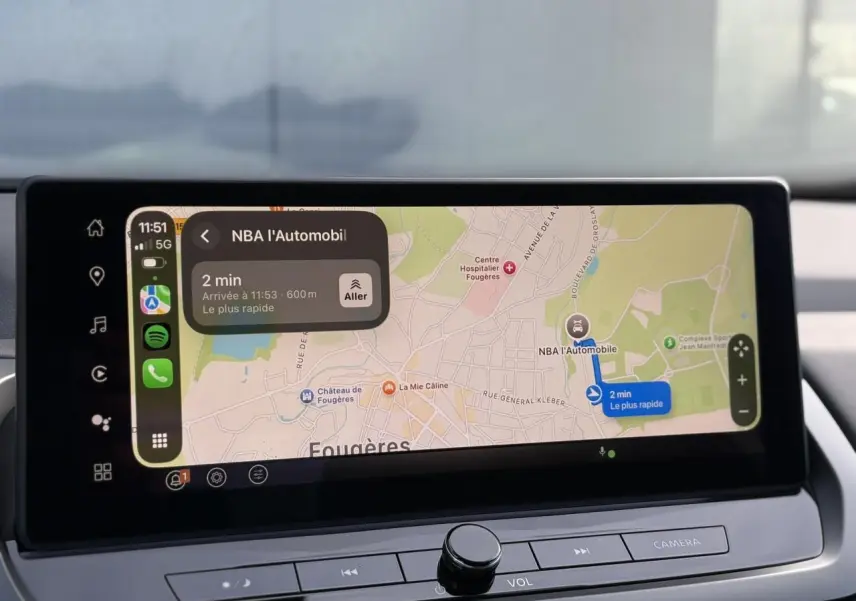 Écran tactile intérieur du Nissan Qashqai blanc nacré 2025 affichant la navigation GPS en mode Apple CarPlay.