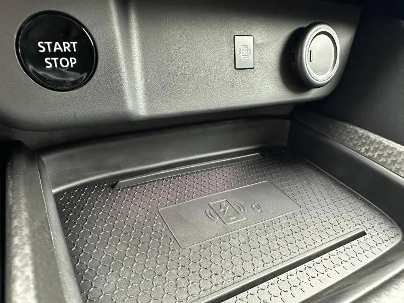 Détail de la console centrale du Nissan Qashqai Hybrid e-POWER 2025 montrant le bouton Start/Stop et le chargeur sans fil noir.