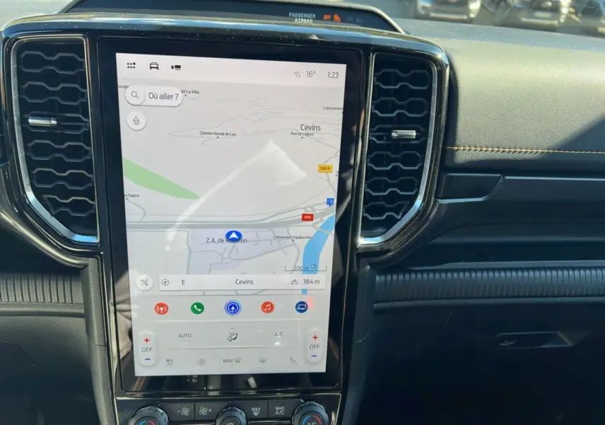 Écran tactile vertical du Ford Ranger 2025 avec navigation, entouré de grilles d’aération noires et tableau de bord noir.