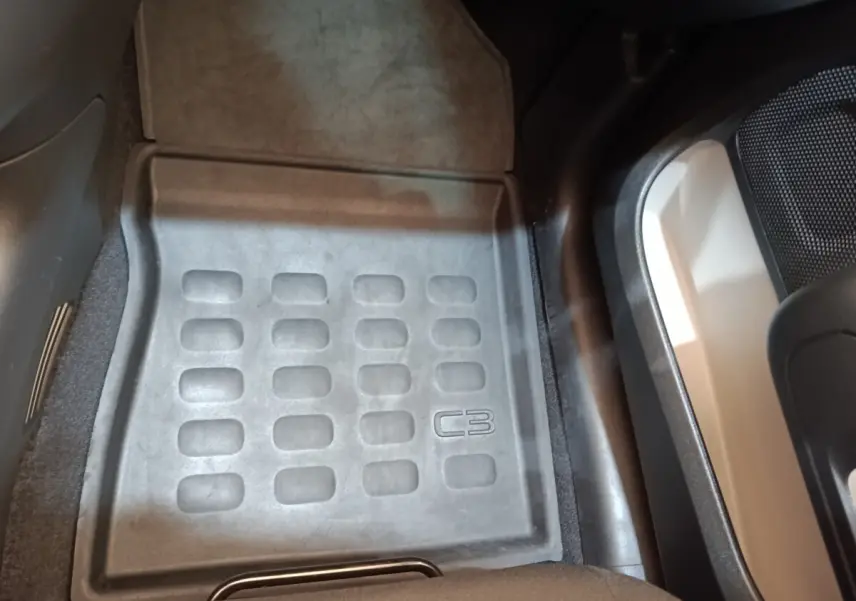 Tapis de sol avant côté conducteur noir avec logo C3 dans l’habitacle d’une Citroën C3 blanche.