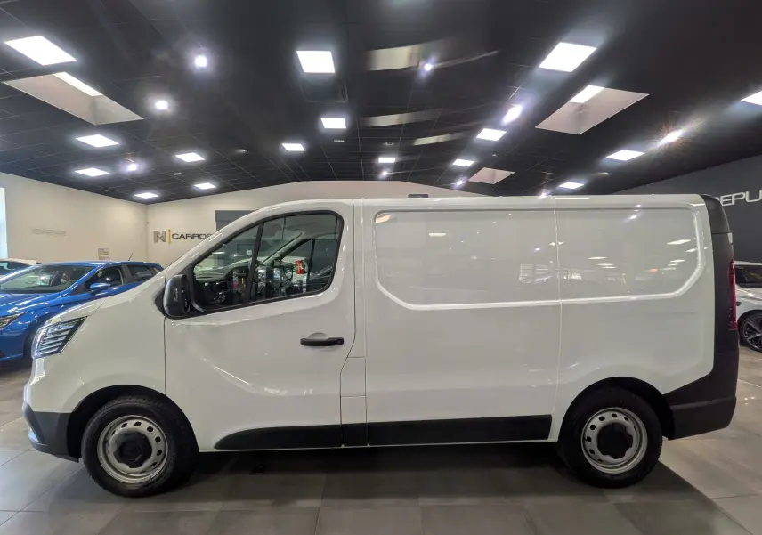Vue de profil côté gauche d’un Renault Trafic Fourgon blanc minéral 2024 en intérieur, avec jantes acier et poignées noires.