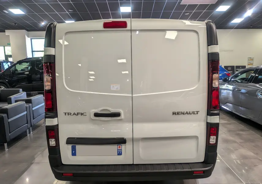 Vue arrière du Renault Trafic Fourgon blanc minéral 2024, avec portes battantes et feux verticaux intégrés.