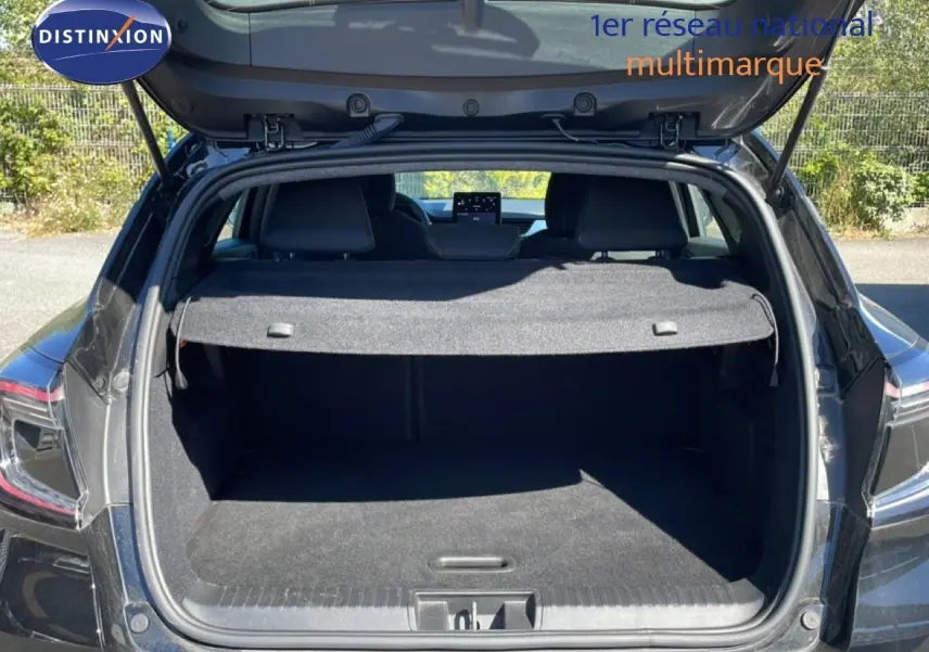 Coffre ouvert vu de l'arrière d'un Renault Captur noir étoile métal, montrant l'espace de chargement et la tablette arrière.