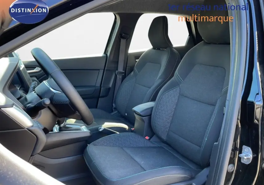 Vue intérieure côté conducteur du Renault Captur E-Tech Full Hybrid 2025, sièges tissu noir étoile métal avec surpiqûres bleues.