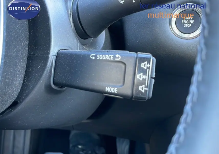 Gros plan sur la commande au volant côté gauche du Renault Captur noir étoile métal, avec bouton start/stop visible.