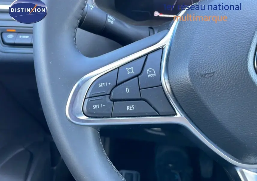 Gros plan sur les commandes au volant du Renault Captur noir étoile métal, version hybride 2025, mettant en valeur les boutons de régulateur.