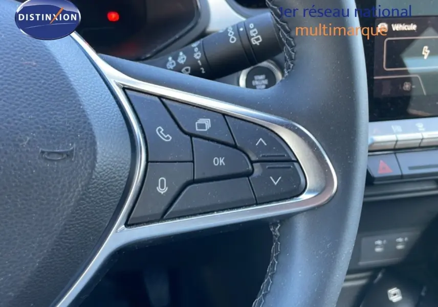 Gros plan sur les commandes multifonctions à droite du volant cuir noir du Renault Captur E-Tech 2025, avec tableau de bord partiel.