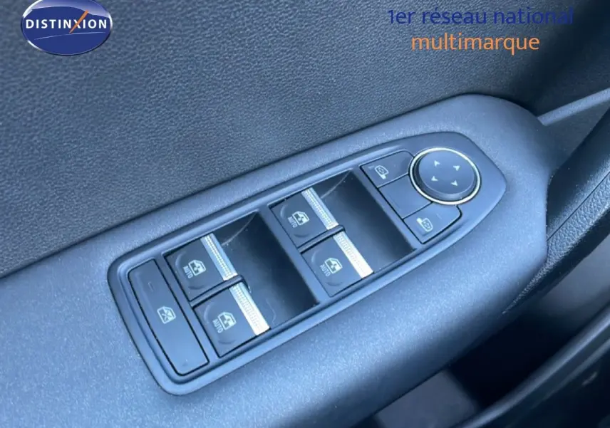 Gros plan sur les commandes des vitres électriques et rétroviseurs côté conducteur d’un Renault Captur noir étoile métal.