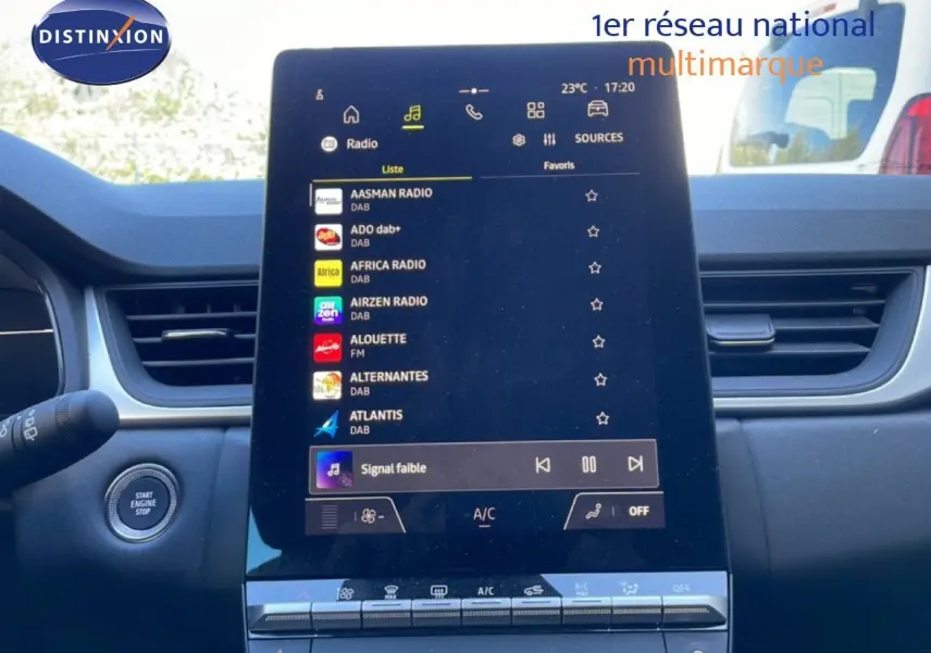 Vue intérieure centrée sur l'écran tactile du tableau de bord du Renault Captur noir étoile métal, affichant les stations radio.