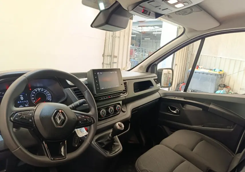 Vue intérieure côté conducteur du Renault Trafic Fourgon 2023, volant multifonctions et tableau de bord moderne.