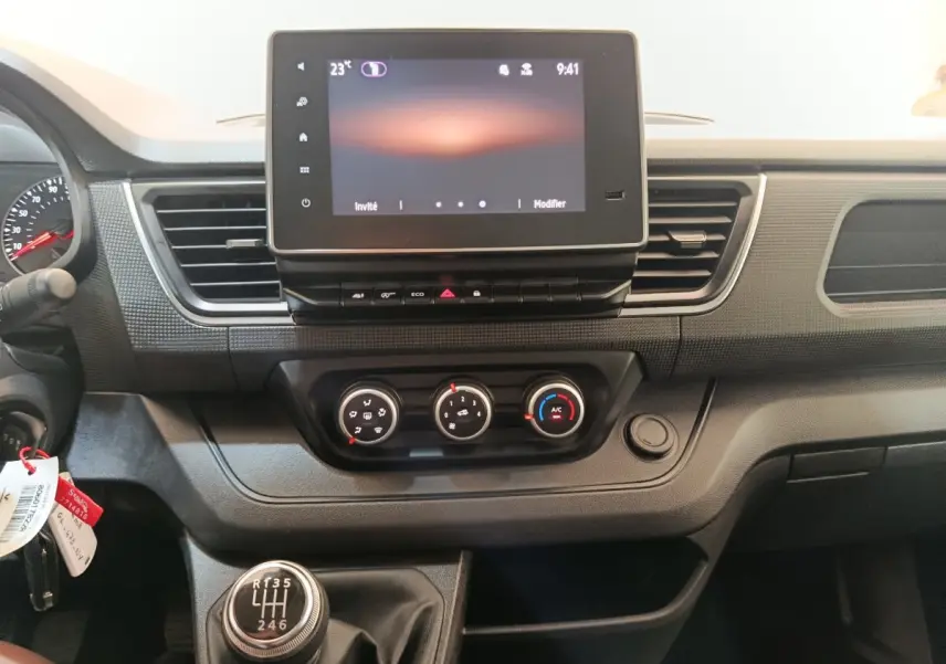 Vue intérieure du tableau de bord du Renault Trafic Fourgon 2023, avec écran tactile et levier de vitesses manuel.