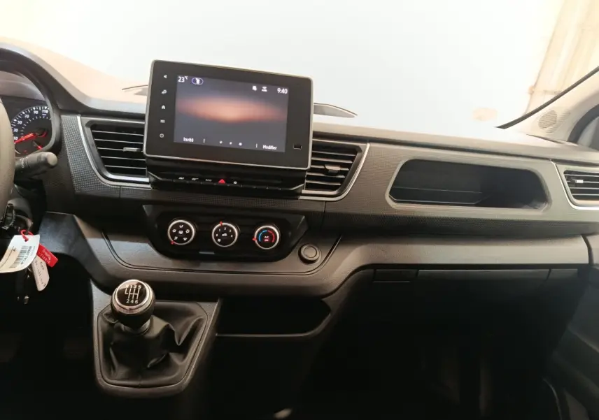 Vue intérieure du tableau de bord du Renault Trafic Fourgon 2023, avec écran tactile et levier de vitesses manuel.