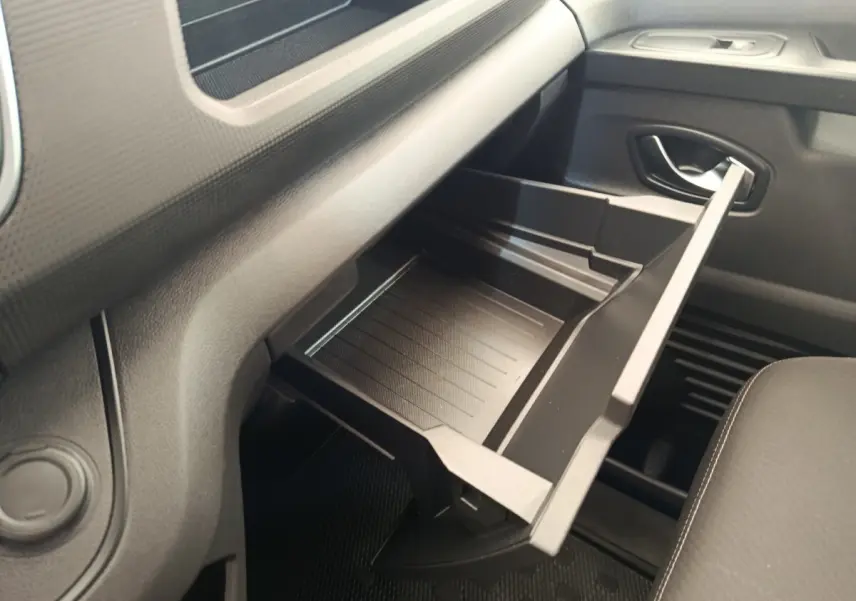 Vue intérieure côté passager du Renault Trafic Fourgon 2023, boîte à gants ouverte en plastique noir.