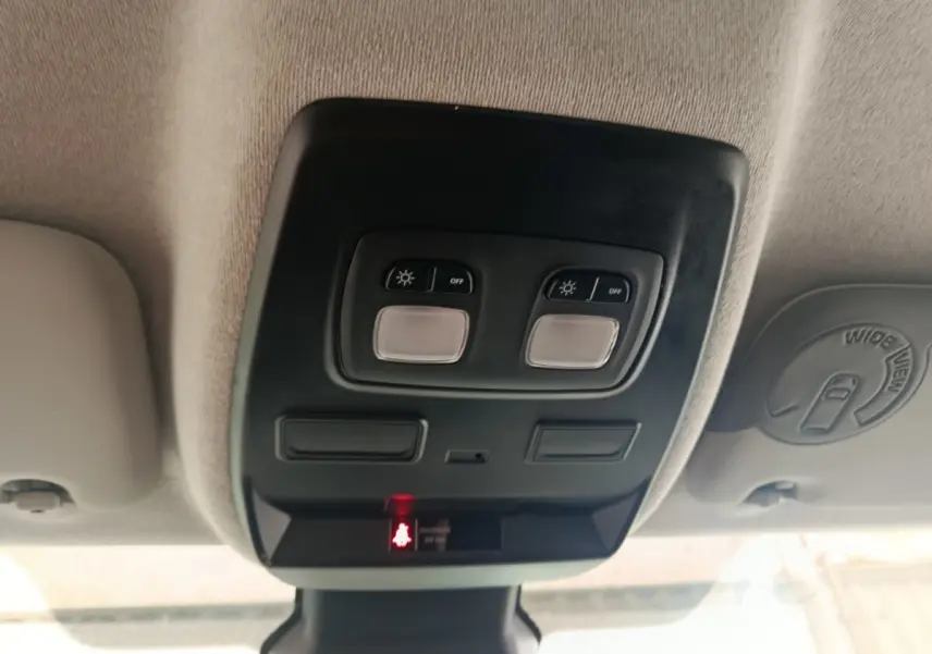 Plafonnier intérieur avec commandes d’éclairage et indicateur de ceinture passager du Renault Trafic Fourgon blanc.